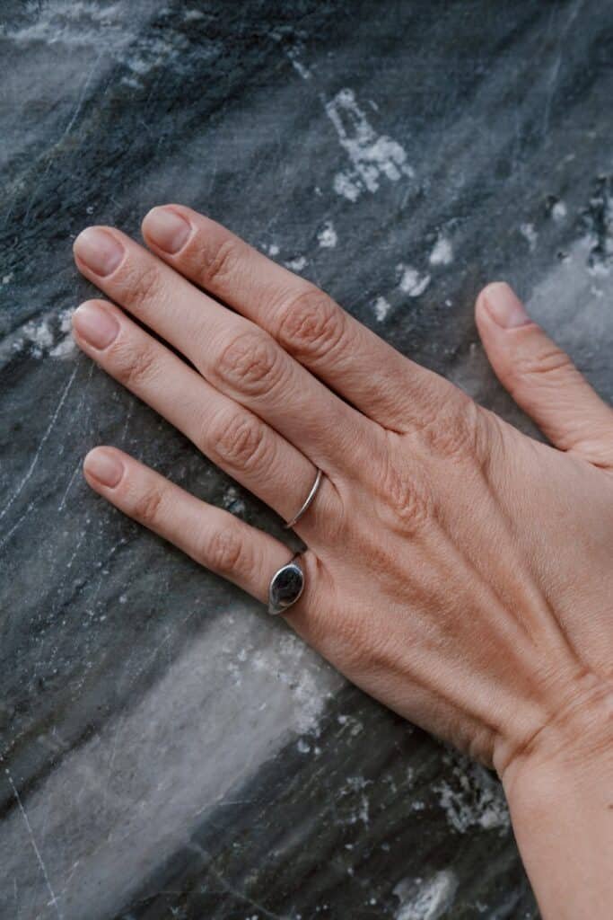 close up of hand on gray and white marble